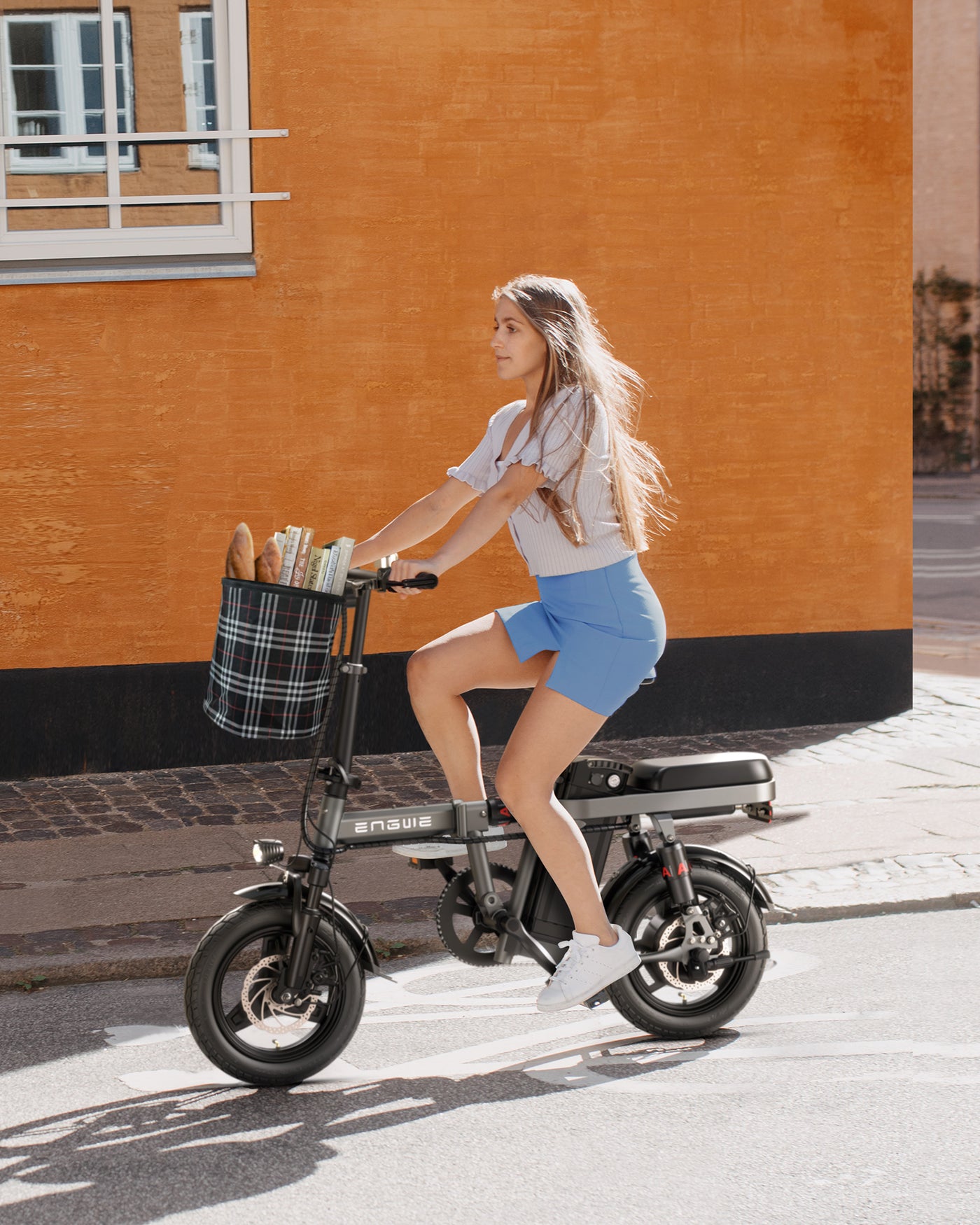 a girl rides a gray engwe t14 electric folding bike on the street