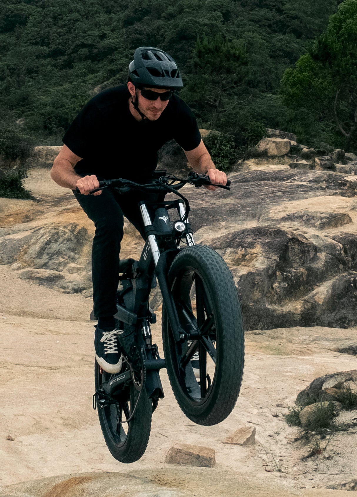 a man rides a black engwe x26 e mountain bike on the sand