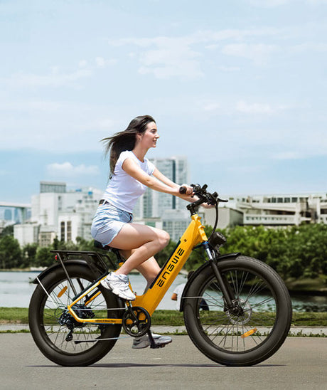 a girl riding a yellow engwe e26 on the city road
