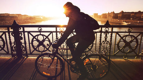 a man riding a bike in the sunset